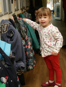 Child hanging up her coat